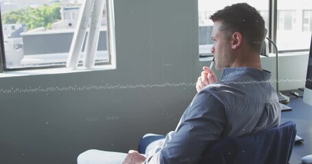 Animation of data processing against thoughtful caucasian man sitting on his desk at office - Powered by Adobe