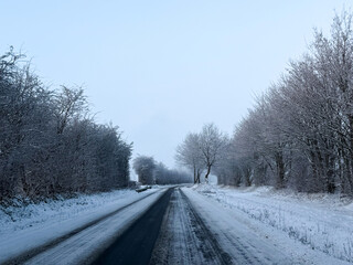 A view of a snow covered road with trees in winter 