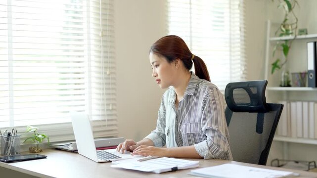 Bored young asian female tired of working sit at home staring laptop screen, lazy business woman frustrated about computer work feeling uninterested demotivated .