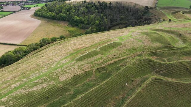 E over Hambledon Hill Iron Age hillfort near Blandford Forum, Dorset. Video fly back from Neolithic long barrow on central ridge reveals fort ramparts