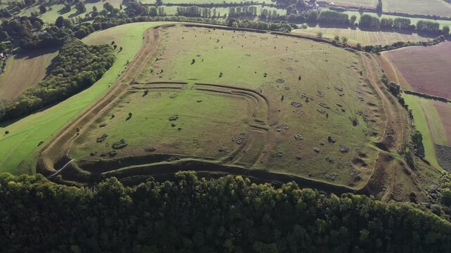 E over Hod Hill Iron Age hillfort. Blackmore Vale, Dorset. Main rampart dates from 500 BC. Once home of the Durotriges. Later Roman fort in NW corner. Video fly in down to Roman fort