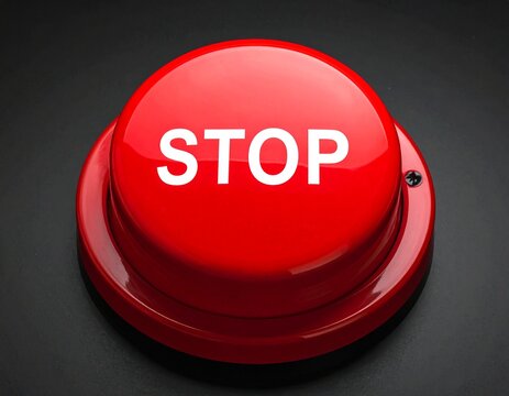 Close-up of a large red stop button with the word STOP in white letters on a black background.