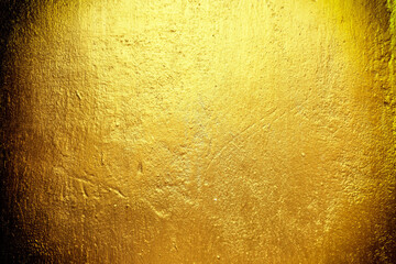 Gold paint on a grunge concrete wall.