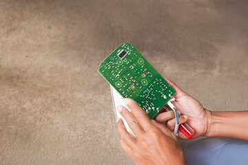 Hand of eletrician man holding electronic circuit board for repairing.