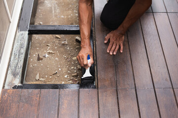 A professional painter is applying anti rust paint to a steel balcony outside a house.