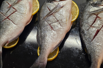 Fresh Sea Bream on Lemon Slices for Culinary Preparation and Grilling