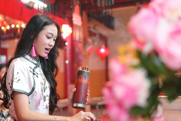 Young Girl Celebrating New Year with Incense and Flowers in Temple
