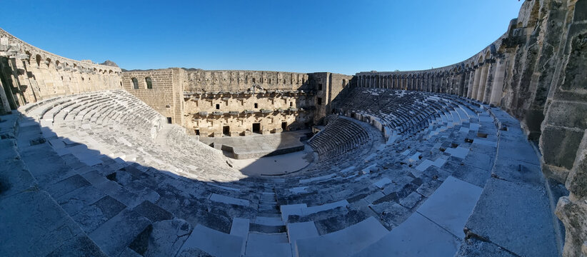 Wide-angle view of the ancient Roman Aspendos Theatre in Turkey, showcasing its remarkably preserved architecture under a clear blue sky