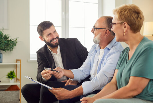 Advisor guides a senior couple through mortgage agreement review, explains terms and checks documents before signing. Financial agent going to sign insurance or investment contract with seniors.  - Powered by Adobe