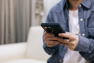 Man hands using a smartphone for texting and social media. Person holding mobile phone. Concept of digital lifestyle, mobile app, and wireless communication. Copy space for adding graphic design