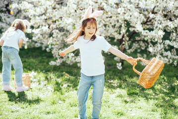Easter egg hunt. Group Of Children Wearing Bunny Ears Running To Pick Up colorful Egg On Easter Egg Hunt In Garden. Easter tradition. Laughing children in park with basket spring concept