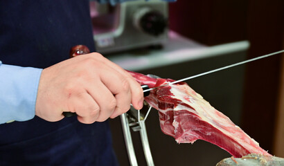 Man Slicing Spanish Jamon with Knife