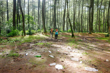 Two Hikers Walking Through Polluted Forest Landscape