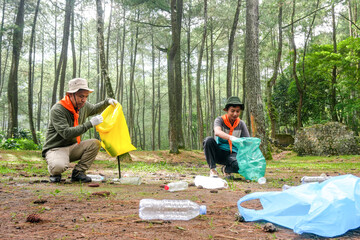 Two Volunteers Cleaning up Plastic Waste in Stunning Forest