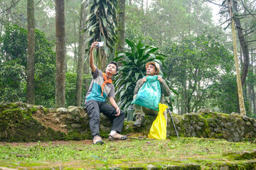 Adventurous Friends Capture Forest Memories on Phone While Collecting Trash