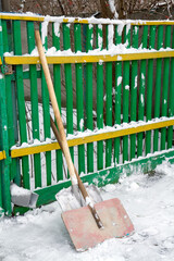Wide shovels for clearing snow in the winter yard. Shovels near the fence