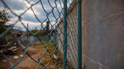 Ground-Level View of Worker Repairing Chain-Link Fence Top Rail