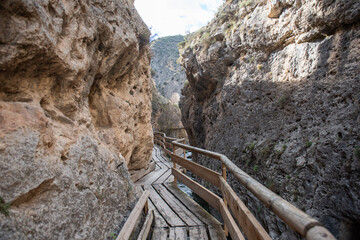 Scenic wooden walkway through narrow stone canyon, nature trail exploration or tourism hiking adventures