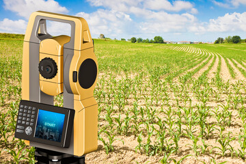 Rural scene with field and 3D rendering of a geodesic device, called Total Station used for the survey of topographic maps and topographical survey