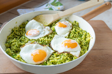 Healthy vegetarian broccoli rice pan with fried eggs sunny side up fresh and homemade cooked in a pan