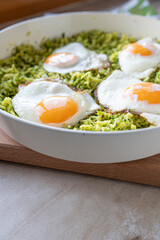 Healthy vegetarian broccoli rice pan with fried eggs sunny side up fresh and homemade cooked in a pan