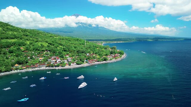 Tropical Aerial Of Jemeluk Bay With Boats And Agung Volcano In Clouds