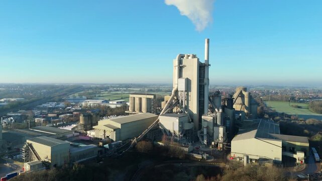 Drone cinematic view of industrial cement factory with towers, chimneys, and aggregates used in construction in Rugby United Kingdom