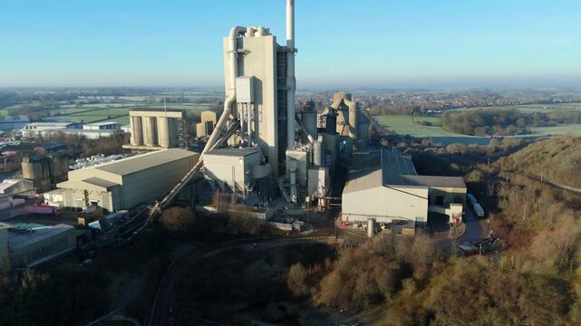 Drone cinematic view of industrial cement factory with towers, chimneys, and aggregates used in construction in Rugby United Kingdom