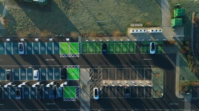 Top down aerial view of EV electrical vehicle charging hubs, modern car technology, no fossil fuels at a service station in the United Kingdom.