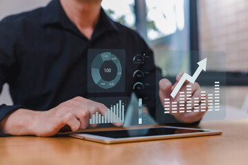 Businessman analyzing financial data with digital tablet and virtual dashboard. Growth chart and data visualization concept for business intelligence, analytics financial technology.