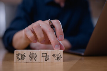 Businessman pointing at wooden blocks with AI brain icons, symbolizing artificial intelligence, machine learning, and neural networks. Concept for innovation, smart technology, and digital thinking.