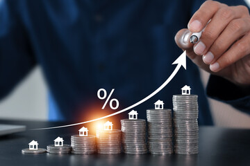 Businessman hand touching a virtual arrow with a percent sign, symbolizing rising real estate values and mortgage rates.