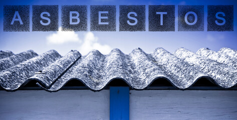 Aged dangerous asbestos roof made of prefabricated corrugated panels with asbestos text