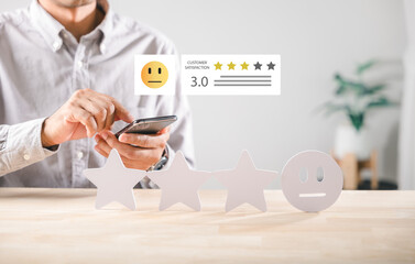 Customer satisfaction service rating shows user giving feedback with smartphone, evaluating three star experience on table, expressing neutral sentiment with survey concept, measuring overall review