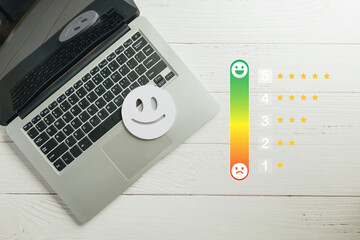 Customer satisfaction survey online, user gives feedback using laptop, star rating system with happy and sad faces illustrates service experience
