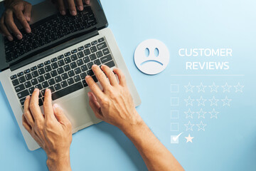 Hands typing on laptop keyboard, customer review displayed with negative feedback and low star rating, indicating client satisfaction issues needing online reputation monitoring and survey data