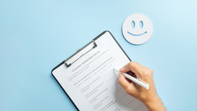 customer satisfaction survey form, hand completing questionnaire for business feedback, collecting client data for service quality review, online checklist, happy face on blue background - Powered by Adobe