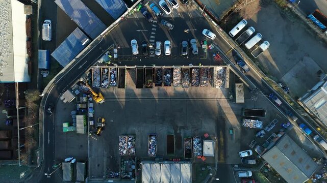 Top down aerial view of recycling centre, garbage disposal and rubbish tip, cars unloading refuse and waste in to skips, Rugby United Kingdom. 