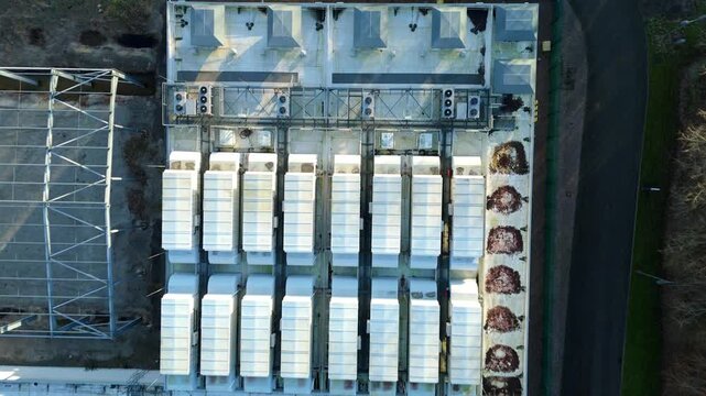 Top down aerial view of large scale data center, ATOS quantum AI computing, cloud storage and technology campus, cooling fans and turbines near Birmingham, United Kingdom