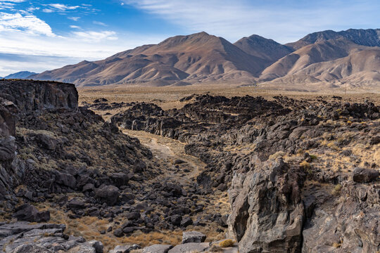 Volcanic rock, Basalt flows. Fossil Falls Trail, Coso Volcanic Field, Inyo County, California.  Coso Range, Basin and Range Province. In the distance is Sierra Nevada ( mountain range )