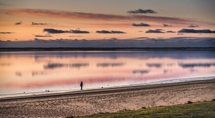 Tranquil Sunset Beach With Silhouette Walker Along Calm Shoreline At Dusk, Hjerting, Esbjerg, Denmark
