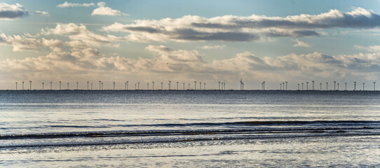 Tranquil Seaside Horizon With Offshore Wind Turbines Under a Cloudy Blue Sky, Blaavand, Denmark