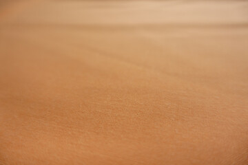 Close shot of unprinted simple muted orange fabric