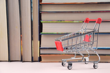 A shopping cart with many books in the background.