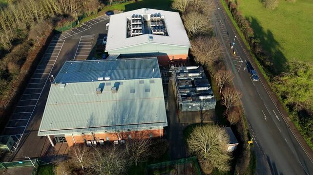 Top down aerial drone view of critical data center infrastructure with HVAC cooling fans and rooftop units supporting quantum computing cloud storage in Redditch UK