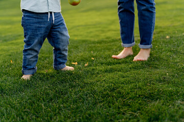 Toddler Taking First Steps on Grass Near Parent