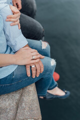 Couple Sitting Together by the Water Holding Hands