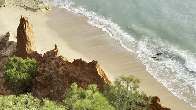 Aerial seascape and coastline cliffs of Praia do Barranco das Belharucas beach, in Algarve region in South Portugal. Praia do Barranco das Belharucas beach, Albufeira, Algarve, Portugal.