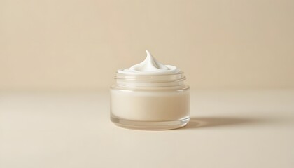Luxurious cream in a clear glass jar on beige background