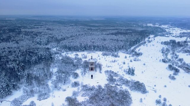 Drone ascends above historic bell tower revealing vast snowy forest horizon, delivering cinematic winter scenery for travel marketing, storytelling, and branding projects